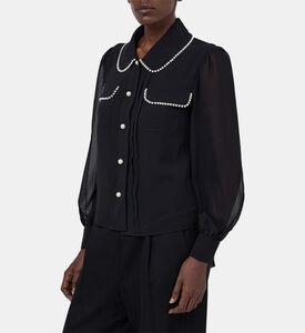 بلوزة بأكمام شفافة مطرزة بلؤلؤ